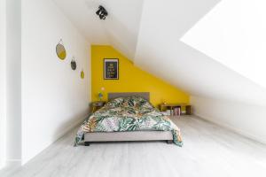 a bedroom with a bed and a yellow wall at @ LOFT COCOONING @ Proche gare & centre historique in Brive-la-Gaillarde