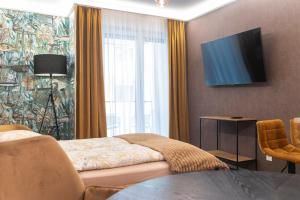 una camera d'albergo con letto e televisore a parete di Grand Suites Central a Budapest
