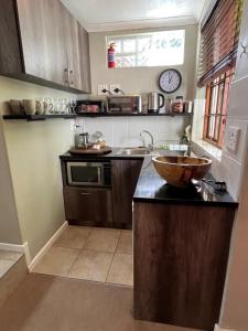a kitchen with a sink and a bowl on a counter at Constantia Guest House in Cape Town
