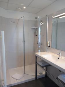 La salle de bains est pourvue d'une douche et d'un lavabo. dans l'établissement Logis Hermitage, à Perros-Guirec