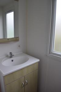 W łazience znajduje się umywalka i lustro. w obiekcie Camping du Creulet w mieście Crouay