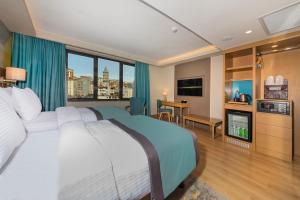 um quarto de hotel com uma cama e uma grande janela em Csk The Halich Port İstanbul em Istambul