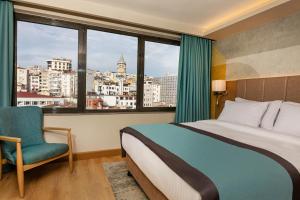 a bedroom with a bed and a chair and a window at Csk The Halich Port İstanbul in Istanbul