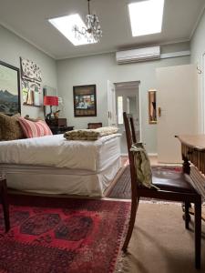 sypialnia z dużym łóżkiem i stołem w obiekcie Constantia Guest House w Kapsztadzie