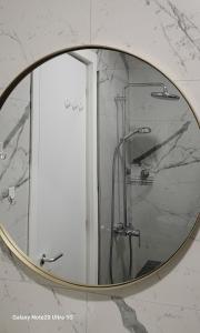 a mirror in a bathroom with a shower at Evergreen Apartment San Pietro in Durrës