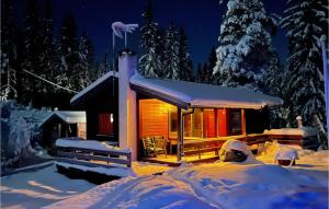 a log cabin in the snow at night at 4 Bedroom Beautiful Home In Snertingdal 