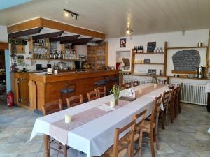 a large dining room with a long table and chairs at Le Castellou in Conques