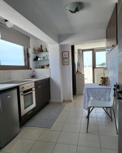 a kitchen with a table and a sink and a table and a chair at Melina Knossos Iraklio Crete in Áno Fortétsa