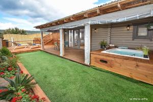 a backyard with a deck and a swimming pool at Suites Tuia in Had Nes