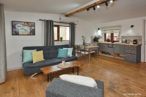 sala de estar con sofá azul y cocina en Suites Tuia, en Had Nes