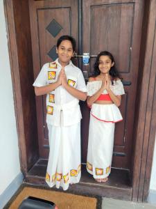 a boy and a girl standing in front of a door at Vidushi Home in Minuwangoda
