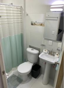 a bathroom with a toilet and a sink at Porto Regina Home in Cancún