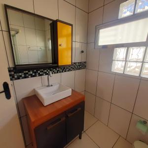 a bathroom with a sink and a mirror at Aconchego do Amor in Pelotas +24 photos