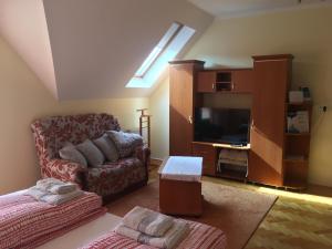 a living room with a couch and a flat screen tv at Jázmin Apartman in Harkány