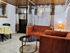 a living room with a couch and a table at Résidence Hôtelière MB-4D in Douala