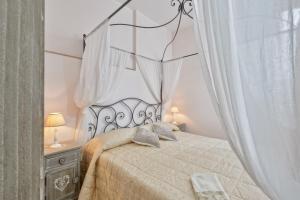 1 dormitorio con 1 cama con dosel en Maison Romantique, en Santa Maria di Castellabate