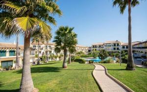 a pathway through a park with palm trees and condos at Condominio Cerro da Guia in Guia