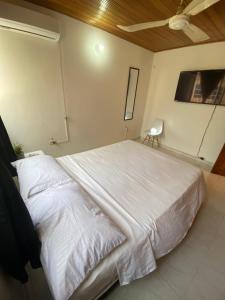 um quarto com uma grande cama branca num quarto em Habitaciones cerca al aeropuerto 2 em Cartagena das Índias
