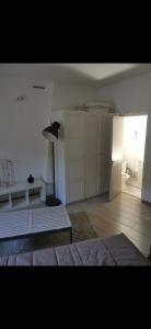 Dieses weiße Zimmer verfügt über ein Bett und einen Kühlschrank. in der Unterkunft Studio Centre ville les halles in Avignon