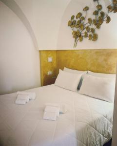um quarto com uma cama branca com duas toalhas em Casetta Melograno em Fasano
