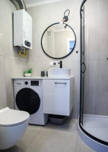 uma casa de banho com um lavatório, um WC e um espelho. em Studio dla Dwojga em Sanok
