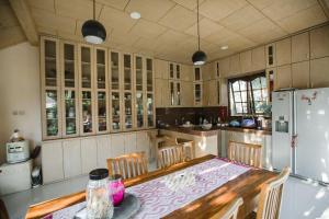 Escotel Villa Marga في تابانان: مطبخ مع طاولة مع كراسي وثلاجة