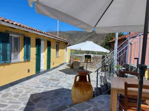 eine große Vase auf einer Terrasse mit Sonnenschirm in der Unterkunft Affittacamere Ca der Culunellu in Soviore