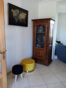 sala de estar con armario y taburete amarillo en Gîte de groupe du Coudray 