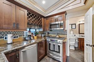 a kitchen with wooden cabinets and a stove top oven at Villa Palazzo D'Stella at the Retreat in Laguna Beach