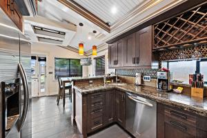 a kitchen with wooden cabinets and stainless steel appliances at Villa Palazzo D'Stella at the Retreat in Laguna Beach