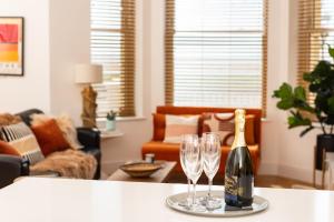butelkę szampana i dwa kieliszki wina na stole w obiekcie 15 Kingsway House w mieście Worthing