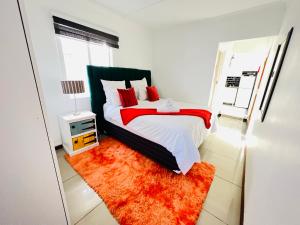 a bedroom with a large bed with a red blanket at Safi Neat & Cozy Suite in East London