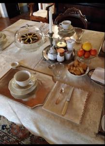 uma mesa coberta com pratos, chávenas e tigelas de comida em Palazzo Bizzarri em Rapolano Terme