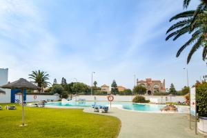 une grande piscine dans un parc avec un palmier dans l'établissement Minarete, à Roquetas de Mar