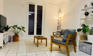 uma sala de estar com uma cadeira e uma mesa em Sweet Home - 55m2 appt, garden, swimming pool, parking em Toulouse