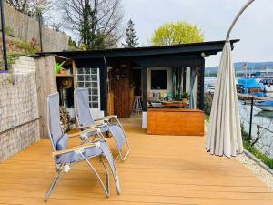 eine Terrasse mit 2 Stühlen und einem Sonnenschirm in der Unterkunft Casa Ländli in Grenzach-Wyhlen