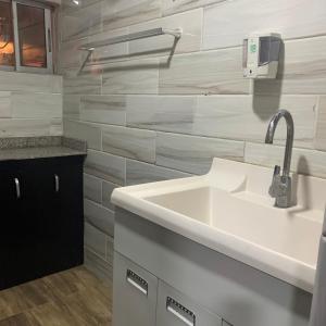 a white bathroom with a sink and a counter at HPLagos BT in Lagos