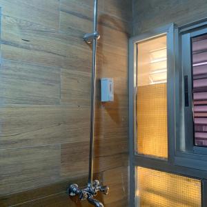 a shower in a bathroom with a wooden wall at HPLagos BT in Lagos