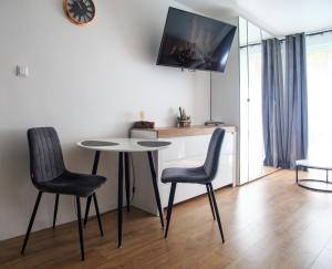 een kamer met een tafel en twee stoelen en een klok bij Studio dla Dwojga in Sanok