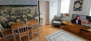 Apartament STOKROTKA في أوستكا: غرفة معيشة مع طاولة و لوحة من الزهور