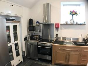 a kitchen with a stove and a sink at 1 Bed Charming Peak District Cottage Barn Near Alton Towers, Polar Bears, Chatsworth House in Leek