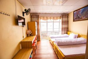 Zimmer mit 2 Betten und einem Fenster in der Unterkunft Nhà Nghỉ Thu Nụ in Mèo Vạc