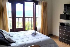 ein Schlafzimmer mit einem Bett und einem großen Fenster in der Unterkunft La Rosaleda 3 - Hermosa finca en Paipa in Paipa