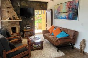 ein Wohnzimmer mit einem Sofa und einem Kamin in der Unterkunft La Rosaleda 3 - Hermosa finca en Paipa in Paipa
