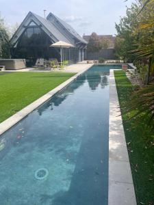 a swimming pool in front of a building at L’Aubépine in Saint-Gervais-la-Forêt