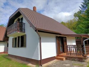 a small white house with a balcony at Vadása Nyaraló in Hegyhátszentjakab