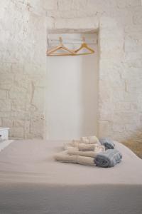 a bed in a room with a white brick wall at Trulli Harmonia con piscina - Alberobello in Alberobello +69 photos