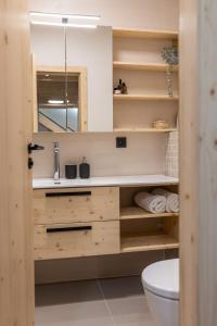 a bathroom with wooden shelves and a sink at Vila Vlasta Apt. #401 in Vysoke Tatry - Stary Smokovec