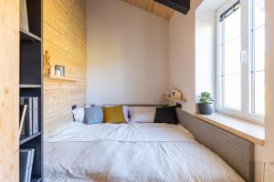 a bed in the corner of a room with a window at Vila Vlasta Apt. #401 in Starý Smokovec