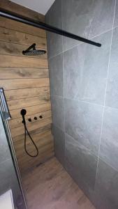 La salle de bains est pourvue d'une douche et d'un mur en pierre. dans l'établissement APARTAMENT 4 bed 2 room WARSAW, à Varsovie